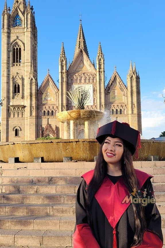 Graduada con toga de doctorado frente a edificio historico