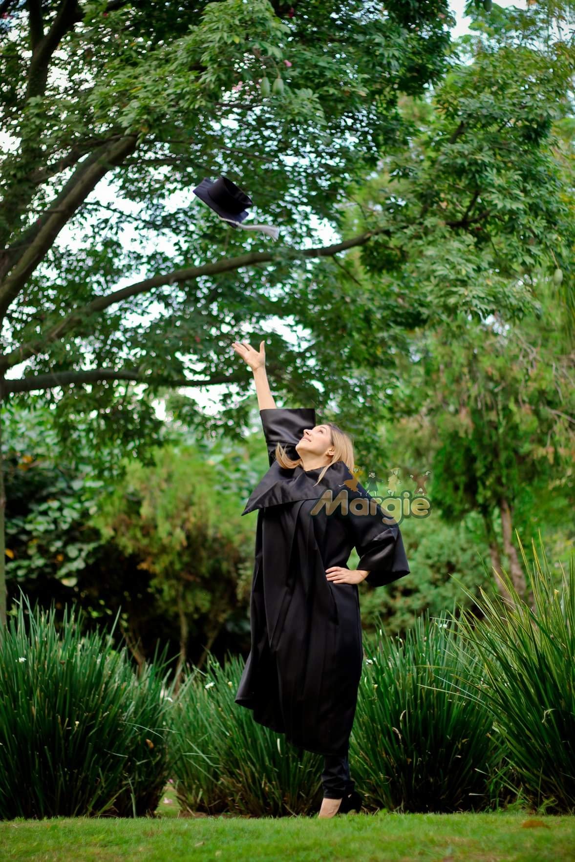 Graduada con toga negra lanzando birrete en Guadalajara