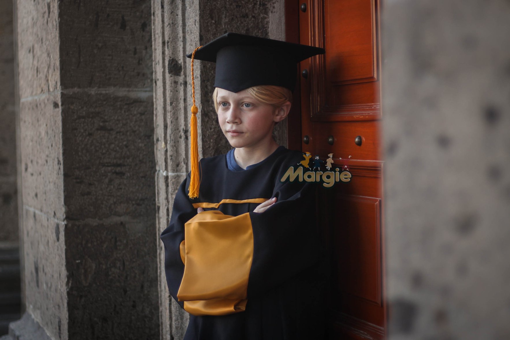 Alumno con toga escolar negra y dorada para graduacion